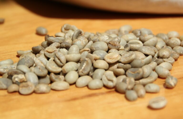 Green coffee beans with a white fabric bag in the background